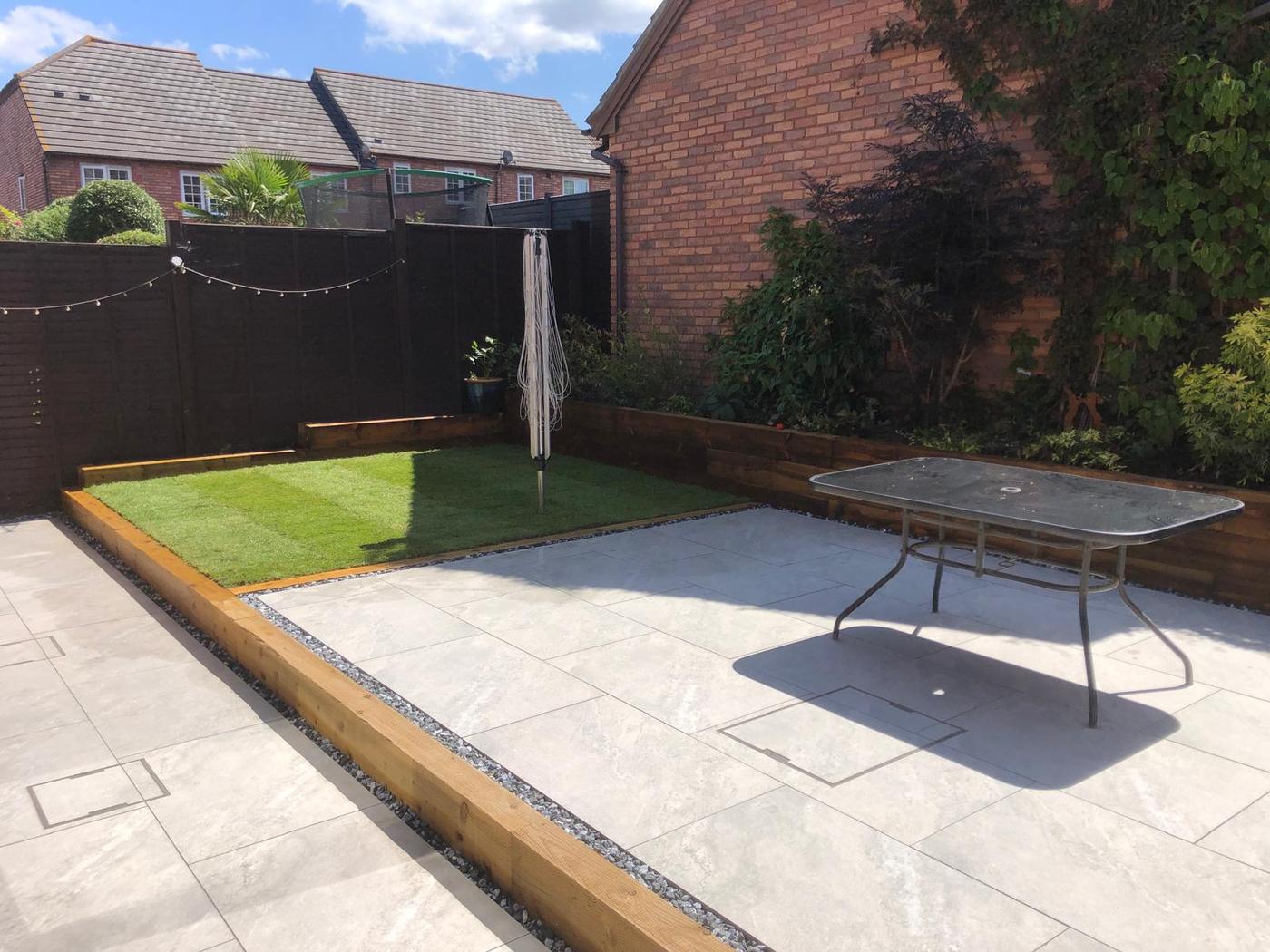 Garden patio with porcelain tiles and raised beds